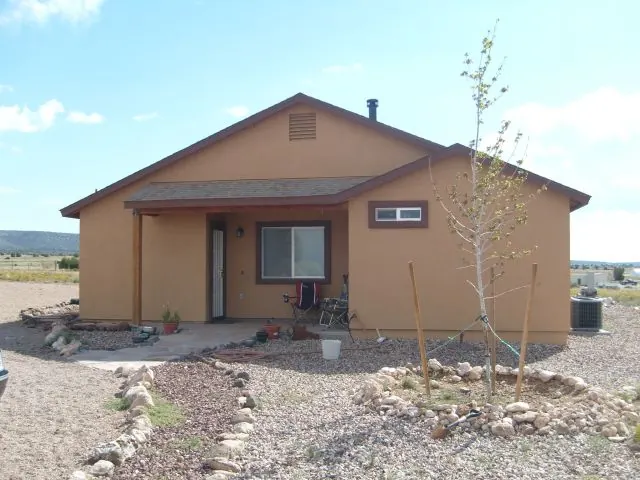 Tan stucco ranch house on open high desert